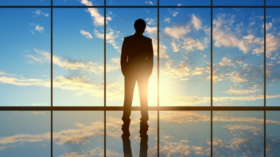 Man at window looking at expansive sunset